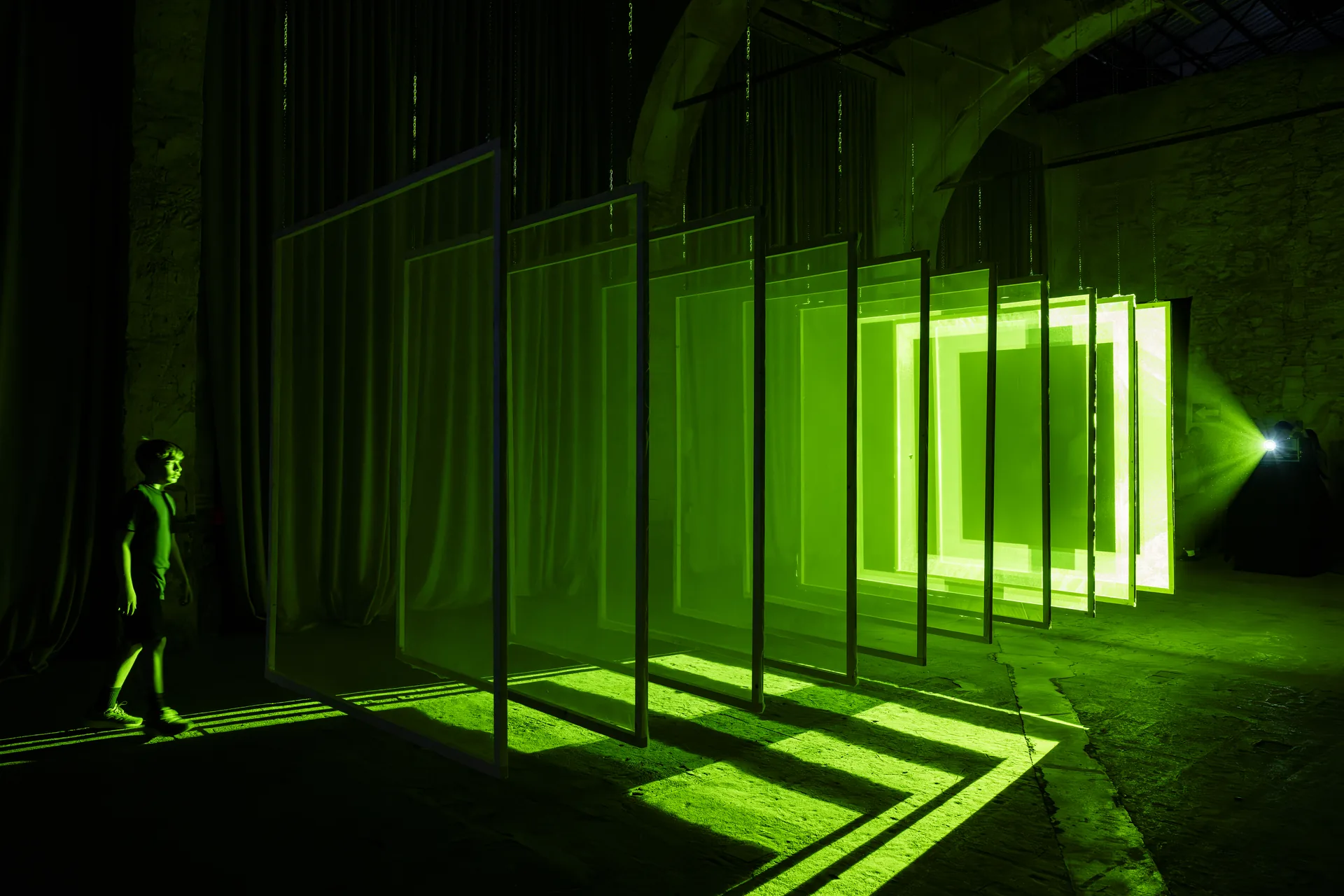 Installazione geometrica di luce verde in uno spazio espositivo Bright